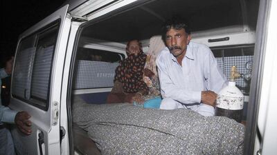 Mohammad Iqbal sits next to his wife Farzana's body. She was stoned to death by her family outside one of Pakistan's top courts in Lahore on May 27, 2014 in a so-called 'honour killing' for marrying the man she loved. Mohsin Raza/Reuters