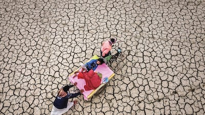 In 'Tears of Drought' by Sharwar Apo, parents take their child to hospital in Rajshahi, Bangladesh, a 16 to 24-kilometre journey across this drought-parched land, the mother holding a saline drip all the way.