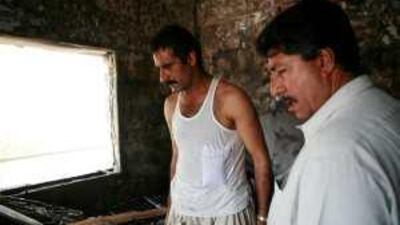Tariq Fazal surveys the damage to his room after a fire in his flat located across from Al Wadha Mall.