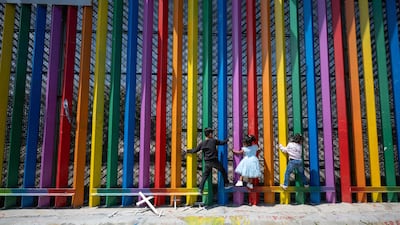 Children play at the Mexico-US border wall during Mother's Day festivities in Playas de Tijuana. AFP