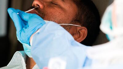A technician takes a nasal swab.