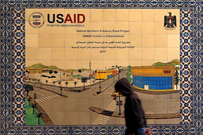 A Palestinian walks past a ceramic sign of a US Agency for International Development (USAID) project in Hebron in the Israeli-occupied West Bank January 31, 2019. REUTERS