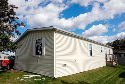 A broken window is seen on a home searched by the FBI in a Hartland Township AFP