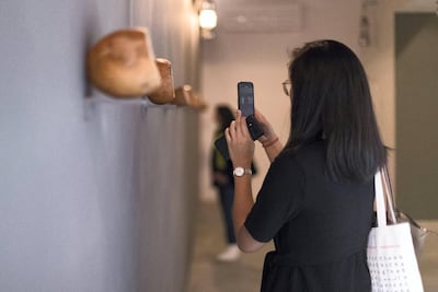 People checking out artworks at Sharjah Biennial 14. The National