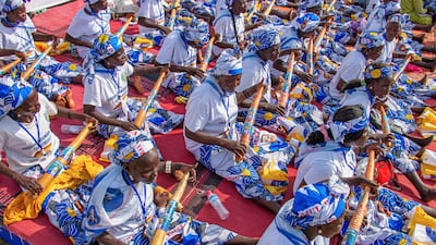 Women dressed in matching patterned outfits hold vuvuzelas printed with the image of President Paul Biya during a political rally at Lamido Yaya Dairou Stadium in Maroua, Cameroon. AP
