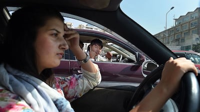 Afghan woman, Rokhsar Azamee, 23, drives her car as Afghan youths stare at her in the streets of Kabul. Since Rokhsar Azamee began driving the streets of Kabul last year, she has endured condescension, ridicule, and even threats to her life with some men deliberately causing 'accidents' to harass her. Wakil Kohsar/AFP Photo