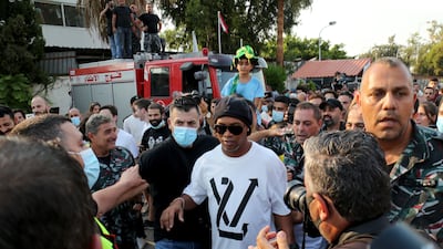 Brazilian footballer Ronaldinho, centre, pays his respects to Lebanese civil defence personnel killed during the port explosion in the capital on August 4, 2020.