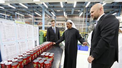 Sultan bin Saeed Al Mansouri, Minister of Economy, centre, takes a tour of the new Can-Pack facility at Dubai Investment Park. Pawan Singh / The National