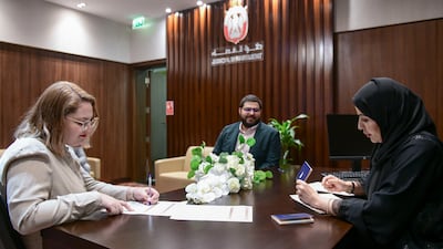 Nogah and Itamar Bareket from Tel Aviv sign marriage documents at Abu Dhabi's civil court in September. Khushnum Bhandari / The National