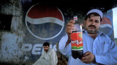 A restaurant owner in Afghanistan holds up a bottle of Mecca Cola. Customers increasingly want to exercise the power of the money in their pockets. Photo by Reza / Getty Images