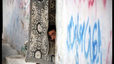 Mat finish: as the funeral of militant Abdallah Mekkawi passes by, a Palestinian man watches from his doorway in Al Brazil refugee camp, Rafah, southern Gaza. Mohammed Saber / EPA