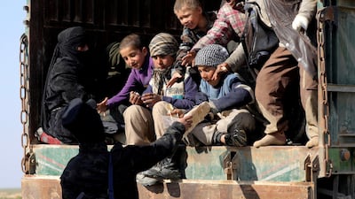 A fighter from the Syrian Democratic Forces gives bread to children near the village of Baghouz, Deir Al Zor province. Reuters