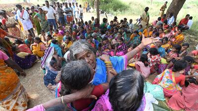 Indian women mourn the death of relatives in a case of food poisoning at Bidarahalli, near Sulawadi village in Chamarajnagar district of Karnataka state, India, Saturday, Dec. 15, 2018. Police on Saturday arrested three people after at least 10 died of suspected food poisoning following a ceremony to celebrate the construction of a new Hindu temple in southern India. (AP Photo/Madhusudhan Sr)