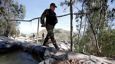 A police officer at an illegal camp in Salpo. Mariana Bazo / Reuters