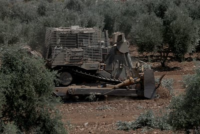 An Israeli bulldozer uproots olive trees from Palestinian farms in Araba village near the West Bank city of Jenin, on Tuesday. EPA