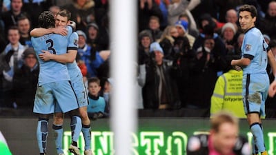 Manchester City's James Milner, second left, is congratulated by teammate Bacary Sagna after scoring his second goal, the late winner for Man City in the FA Cup third round on Saturday against Sheffield Wednesday at the Etihad Stadium. Oli Scarff / AFP