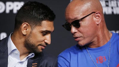 Amir Khan, left, speaks with trainer Virgil Hunter during the press conference. John Locher / AP Photo