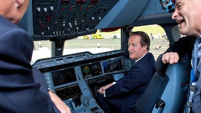 British prime minister David Cameron, second right, sits in the cockpit of an Airbus A350 aircraft on the first day of the Farnborough International Airshow. Ben Gurr / AFP