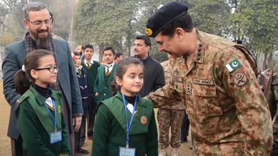 Pakistani Army chief Raheel Sharif, right, speaks with students at the Army Public School after it was reopened. AFP Photo