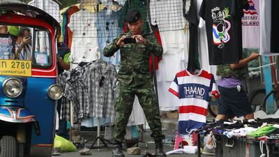 A soldier photographs the scene of an explosion on February 23, 2014, at an anti-government protest site in Bangkok, Thailand. More than a dozen people were hurt in the explosion less than a day after a bloodier attack in an eastern province killed one child and left about three dozen people wounded. Wally Santana / AP photo