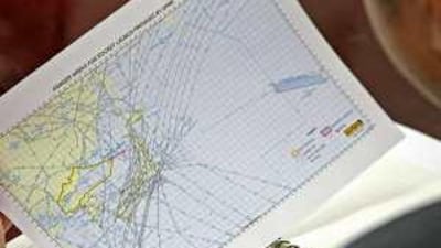 A South Korean officer looks at a map provided by North Korea showing areas in danger from a rocket carrying a "communications satellite" that Pyongyang says will be launched in early April.