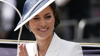 The Duchess of Cambridge wears a white dress coat, thought to be Alexander McQueen, with a black and white Philip Treacy hat and a pair of sapphire earrings for Trooping the Colour. PA