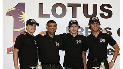 Jarno Trulli, second right, Heikki Kovalainen, left, and Malaysia's Fairuz Fauzy, right, pose with the Lotus F1 racing team principal Tony Fernandes at a press conference in Kuala Lumpur.