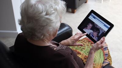 A grandmother looks at photographs of her grandchildren. New technology can be tricky for older people to master. (Photo: Simon Dawson/Bloomberg)