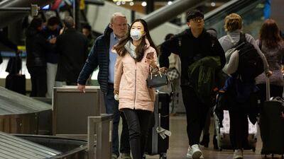 A traveller wearing a face mask walks inside the Seattle-Tacoma International Airport (SEA) in Seattle, Washington. Shares of long-haul flight operators Air France, Lufthansa and British Airways-owner IAG retreated, as news of the latest viral lung illness contagion raised concerns among investors. Bloomberg