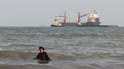 An Iranian women enjoy a dip in the sea as vessels are seen in the Strait of Hormuz off the port city of Bandar Abbas, in southern Iran. AFP