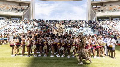 A member of the Amabutho dances in front of Zulu women clad in traditional dress. AFP