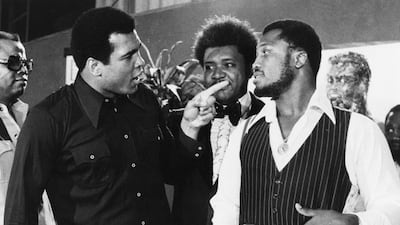 In this July 17, 1975, file photo, sports promoter Don King stands between Muhammad Ali, left, the heavyweight champion, and Joe Frazier in New York. AP Photo file