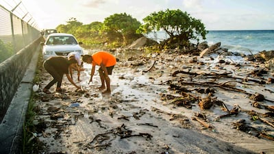 High-tide flooding and debris covering a road in the Marshall Islands capital, Majuro, in December 2021. AFP