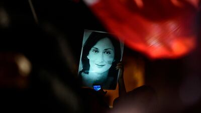 A protester holds up a picture of murdered reporter Daphne Caruana Galizia on the fourth day of a demonstration outside Malta's prime minister's office in Valletta, Malta. AP Photo