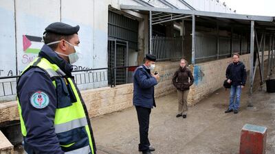 Palestinian security forces wearing masks block the entrance to the crossing gate between the Israeli occupied West Bank city of Bethlehem and Jerusalem. EPA