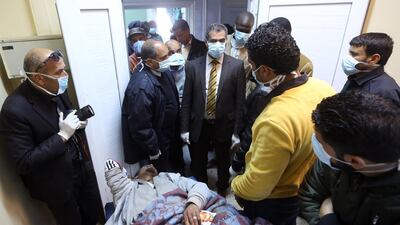 Colonel Mohamed Bashir, director of Libya's Illegal Immigration Control Agency, checks on an African mgirant who was injured after their vehicle was overturned during a truck collision, at a hospital in the town of Beni Walid. Mahmud Turkia/ AFP Photo