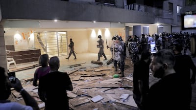 Demonstrators stand before Lebanese security forces after protesters and families of the Beirut blast victims broke into the residence of Lebanon's interior minister in the Qoraitem neighbourhood of western Beirut.