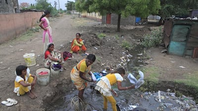 Villagers collect water from a over flowing pipeline & use the unhygenic unfiltered water for washing & drinking. Subhash Sharma for The National