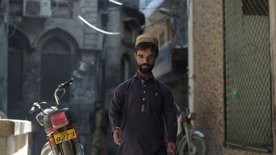 Rozi Khan, 25, walks on a street in Rawalpindi. AFP