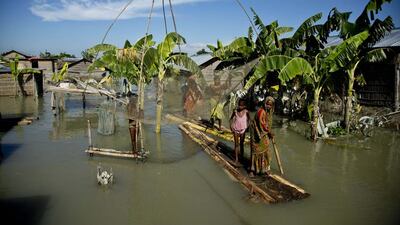 A flood affected family moves on a banana raft past a fishing net in Morigaon district, east of Gauhati, northeastern Assam state, India. Anupam Nath / AP Photo