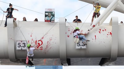 Activists spray 'Enough' in Hebrew on Yehudit Bridge in Tel Aviv, as families of Israeli hostages held in Gaza and their supporters mark 600 days since the captives were taken. EPA