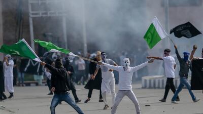 Masked Kashmiri protesters hold Pakistani flags during a protest after Eid prayers in Srinagar, Indian-controlled Kashmir, on June 16, 2018. Dar Yasin / AP