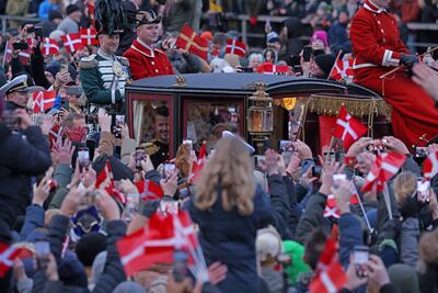Newly-crowned King Frederik X and his wife Queen Mary wave to the crowds as they leave Copenhagen's Christiansborg Palace in a carriage on Sunday. Getty Images