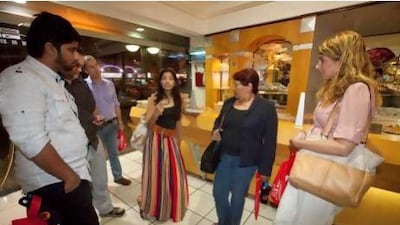 Arva Ahmed, centre, with one of her walking food tour groups at Samadi Sweets in Deira. Jaime Puebla / The National