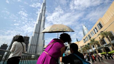 Visitors to Dubai Mall take pictures of the Burj Khalifa in Downtown Dubai, the district developed by Emaar Properties. Chris Whiteoak / The National