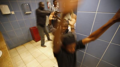 Police search people in a bathroom during the attack. The gunmen carried AK-47s and wore vests with hand grenades on them, said Manish Turohit, 18, who hid in a parking garage for two hours. “They just came in and threw a grenade. We were running and they opened fire.” Goran Tomasevic / Reuters