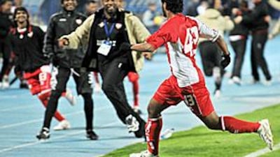Sultan al Menhali runs to greet his teammates on the sidelines after scoring the UAE's winner against Uzbekistan.