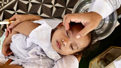 A priest baptises a child during a mass baptism ceremony at the San Martin De Porres Church in Bacoor city, Cavite province, south-west of Manila, Philippines. EPA