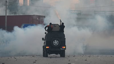 Officers fire tear gas shells to disperse supporters of Mr Khan, in Islamabad. AP