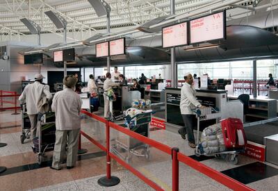 Passengers check in at the Air Arabia counter at Sharjah International Airport in 2009. Jeff Topping / The National